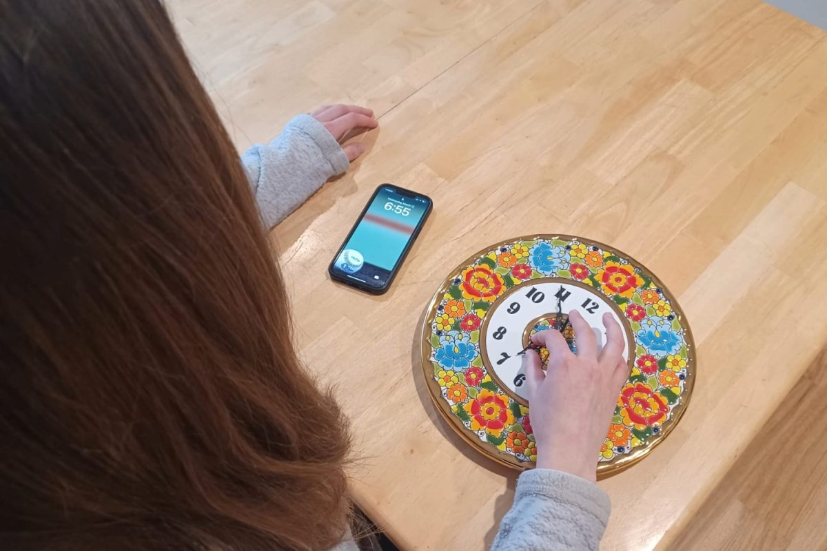 A Carlmont student sets her clock forward one hour, using her phone time as reference. As the debate over daylight saving time continues, the necessity and practicality of changing clocks has been questioned. Some believe that the time change should be ended. "I think the pro argument has already been discounted, and that's part of the problem," said Alya McGinlay, a Carlmont parent.