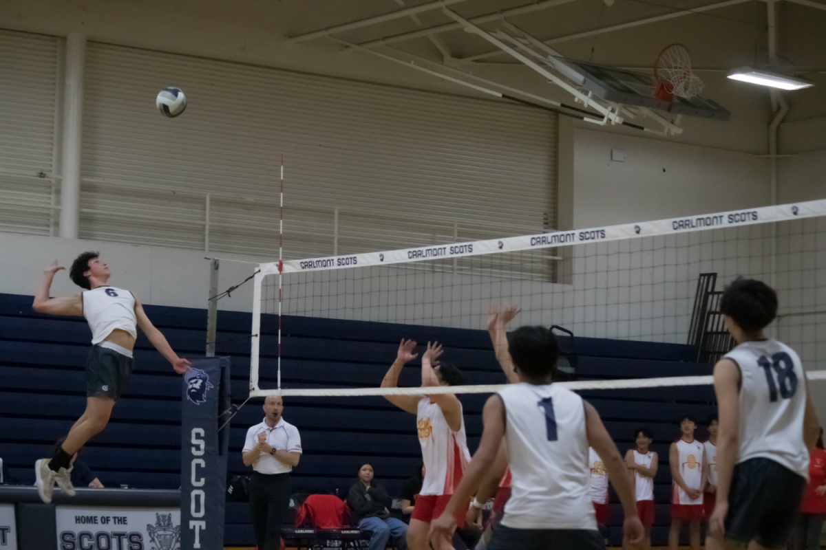 Sophomore Jonathan Edwards prepares to spike the ball over the net as the opponents get into defensive position. Moments earlier, a well-placed set from sophomore Tyler Louie gave Edwards the opportunity for an aggressive attack. "In big moments during the game, our mindset is fixed on doing what we can do to win the set and trying our best," Louie said. 