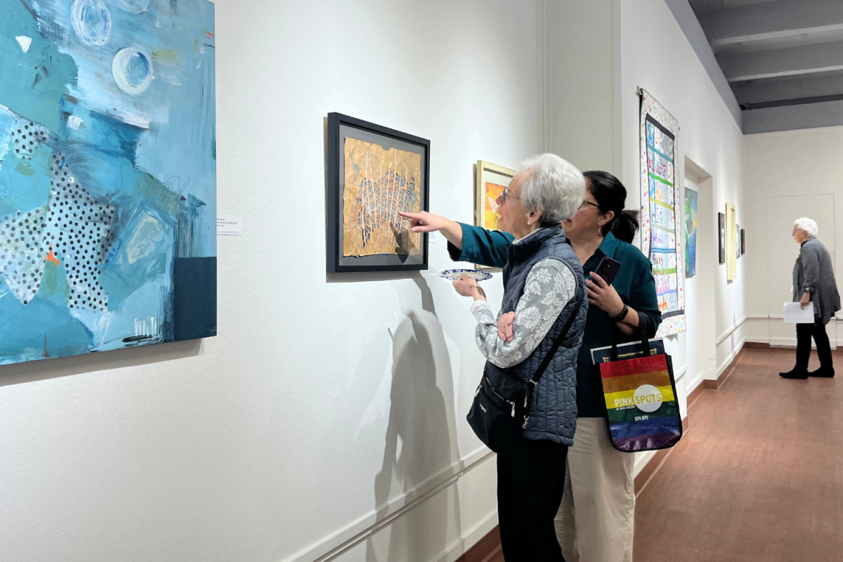 Attendees of the Women’s View art exhibition closely examine a painting, discussing its details and interpretations. “Women have most often been portrayed in art rather than being the ones portraying others," said Cheryl Selman, a featured artist. "While there have been a few famous female artists throughout history, they are relatively rare and usually don't hold the same significance in people's minds as their male counterparts.”