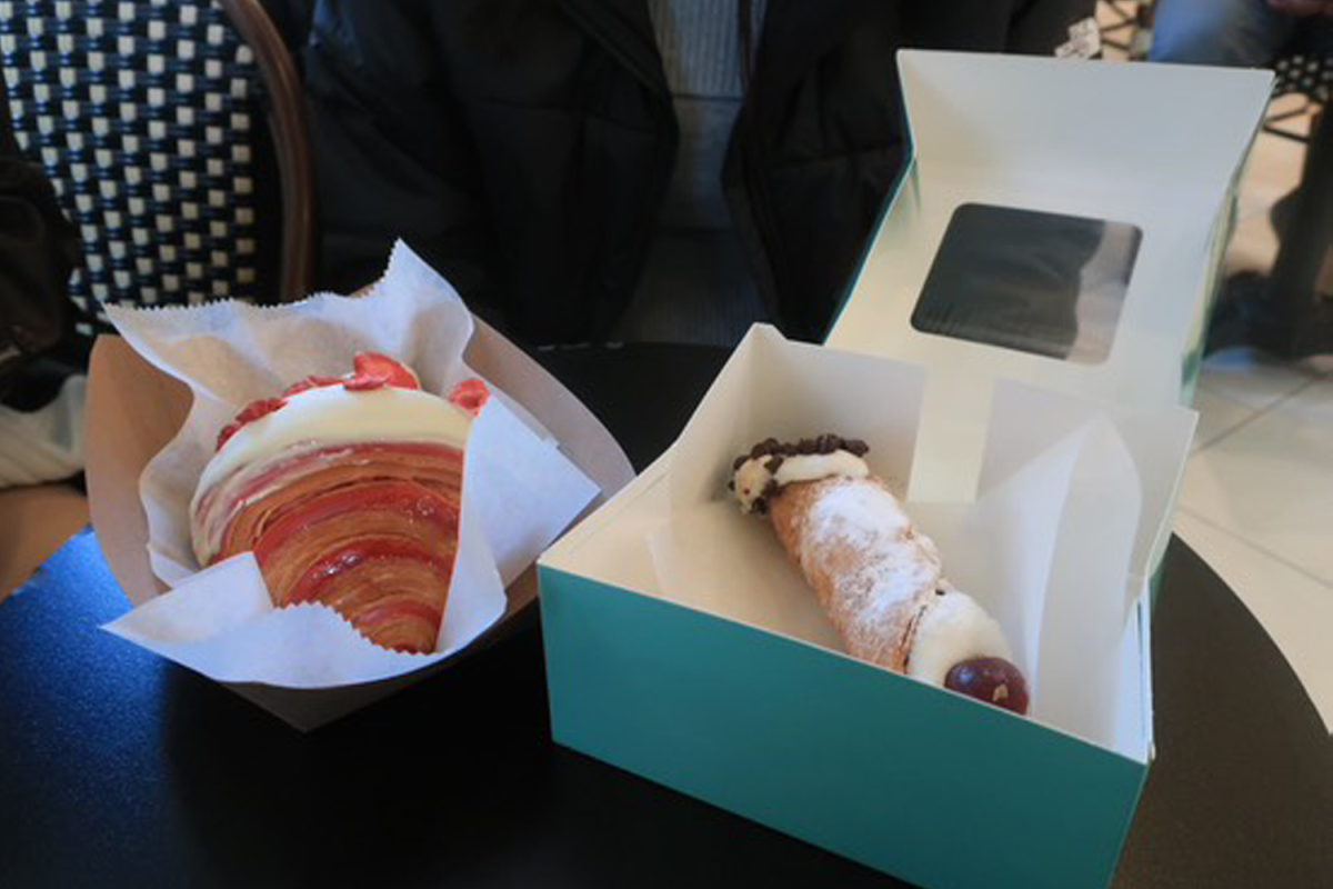 Senior Mattie Llido and sophomore U'iwailani Loboto pose with the signature teal boxes of Angelina Bakery. Their colorful array of pastries give the perfect sweetness for any craving.