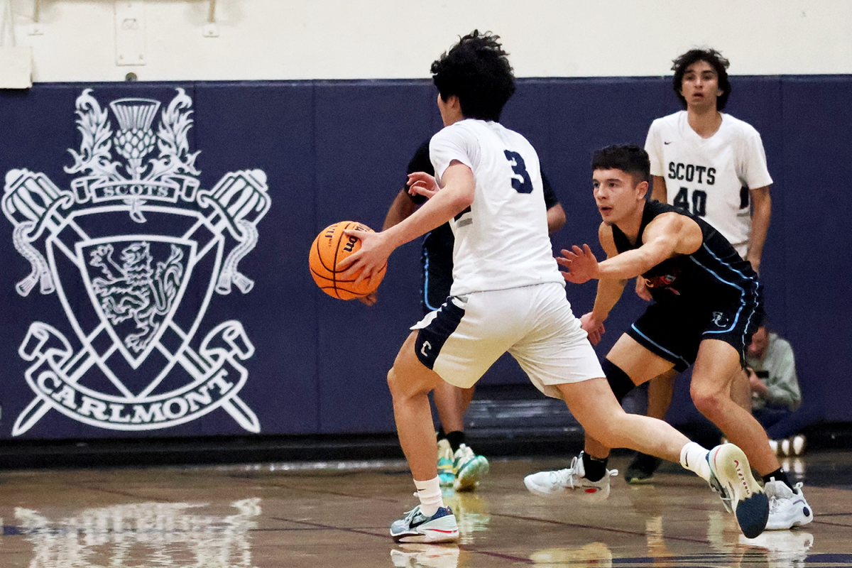 Senior Camden Ngo dribbles the ball up the court as a defender presses him. During the game, the Gauchos played a full-court press, which made it difficult for the Scots to get to their offensive half successfully. A full-court press is a defensive strategy in basketball where the defending team pressures the opposing team across the entire court. 