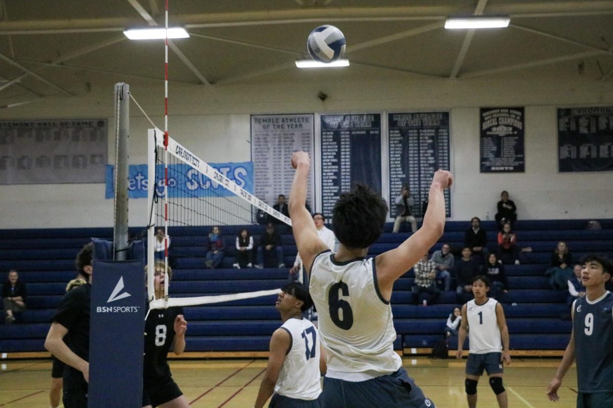 Carlmont sophomore Jonathan Edwards jumps up to spike the ball. He made fists with his hands so the hit was more powerful and less painful. This allowed him to slam down a powerful shot and score a point.