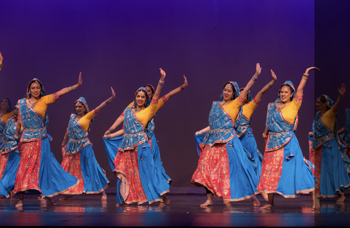 Dressed in bright blue and yellow chaniya cholis, dancers move with grace and joy during a high-energy segment performed by the alumni Sangeet group.