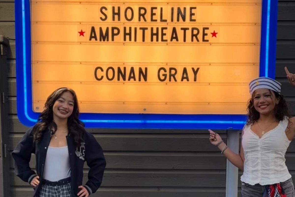 Fans Sophie Lin and Milena Stoyanov pose in front of a concert venue banner. Both high school students attended the Conan Gray Wishbone Pajama tour on Oct. 3, describing the atmosphere and vibes of the experience. “It’s such an interesting venue to see a concert in, and the way Conan sang, how he performed, combined with all of his fans screaming along, felt so unique,” said Sophie Lin, a freshman at Menlo-Atherton High School. 