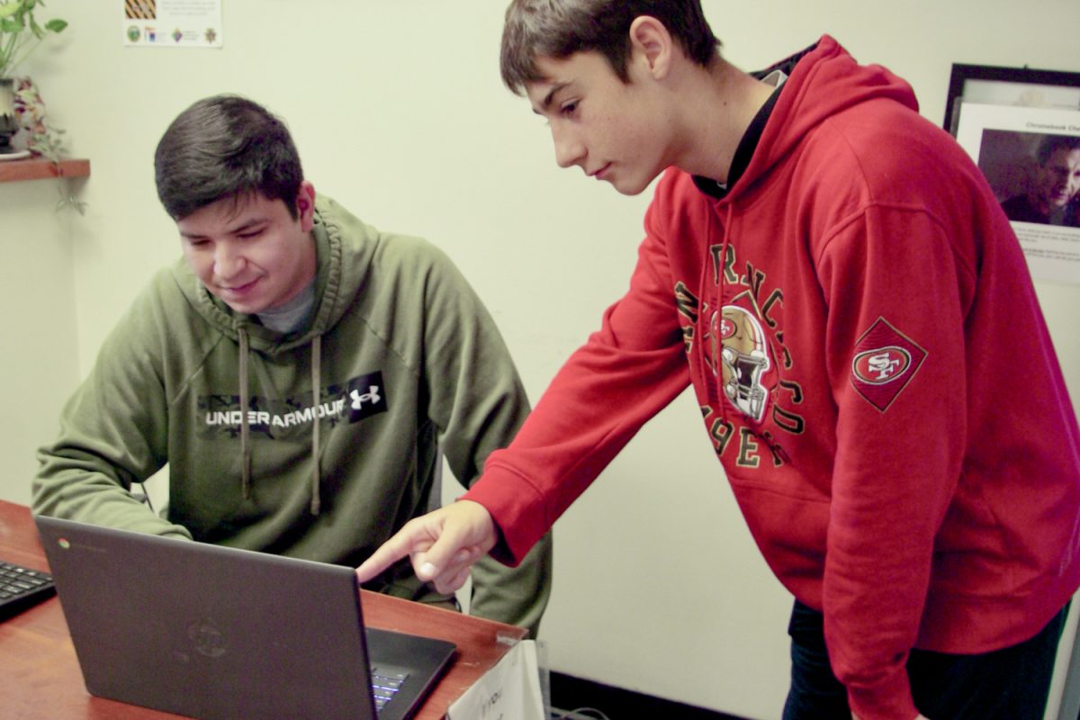 Alfredo Cornejo, the Site Technology Manager at Carlmont, assists a student with tech difficulties. According to Cornejo, phishers can exploit a compromised staff member's account to solicit personal data from students via the staff member's email. "Things like names, addresses — I've seen them ask for banking details," Cornejo said.