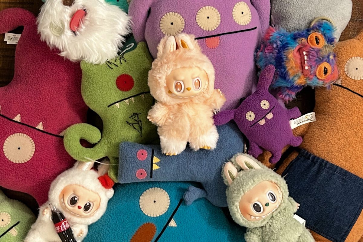 A mixture of UglyDolls, Fugglers, and Labubus are piled together on a table, representing the growing trend of "ugly-cute" collectables. "Part of the reason I find the idea of toothy bears so funny is because it straddles the line between everything I find scary, and everything that's meant to feel comforting," Fuggler creator Louise McGettrick said when explaining the meaning behind the realistic teeth on the Fugglers.  