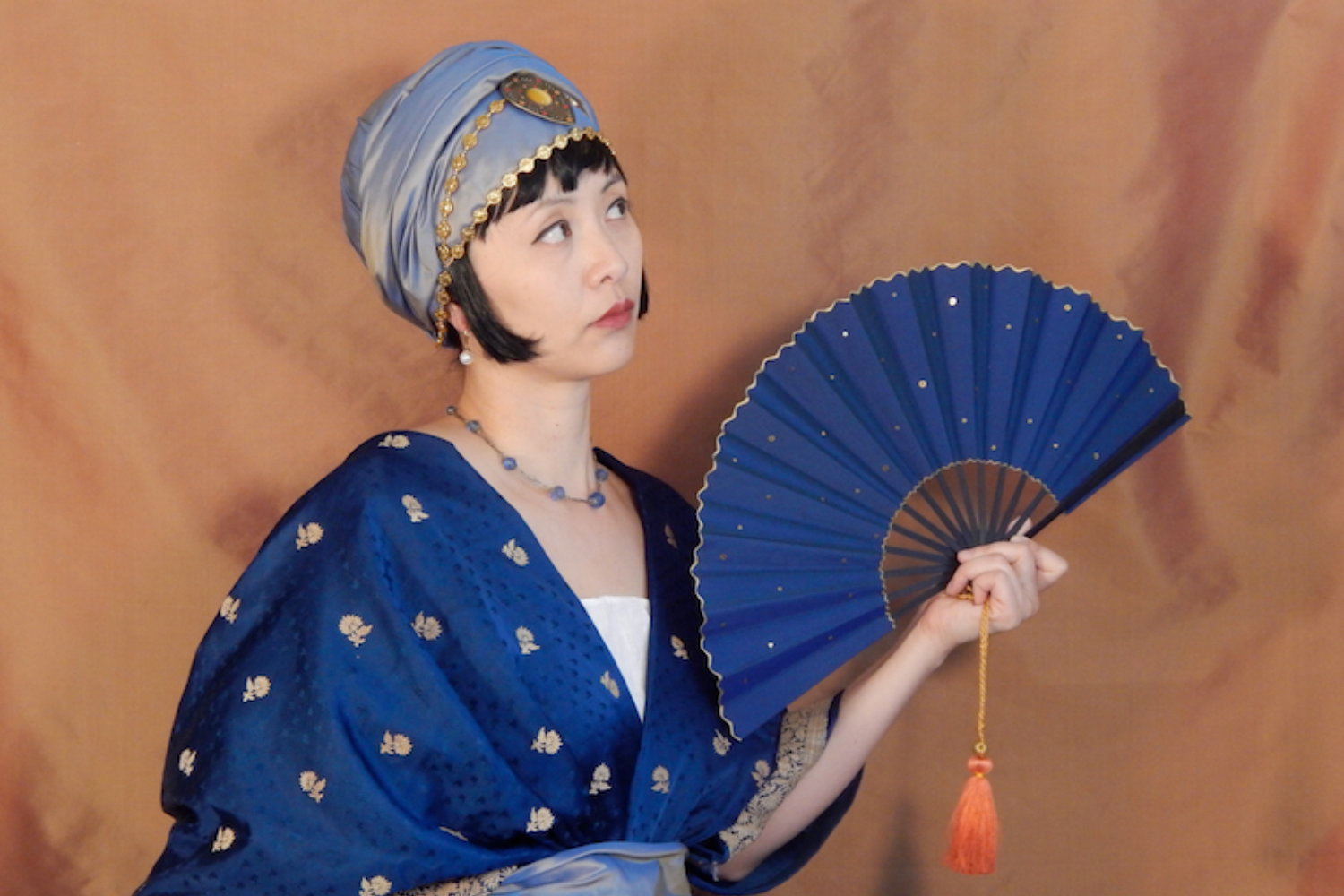 Claudine Wong models a Paul Poiret-inspired turban crafted out of Indian textile fabric. Along with the turban, McMasters also designed a rich blue fan, which is made out of stiffened taffeta material with gold paillette and a wavy edge. All of McMasters' designs can be found on the website for her business. (Photo courtesy of Lynn McMaster, outofaportrait.com)