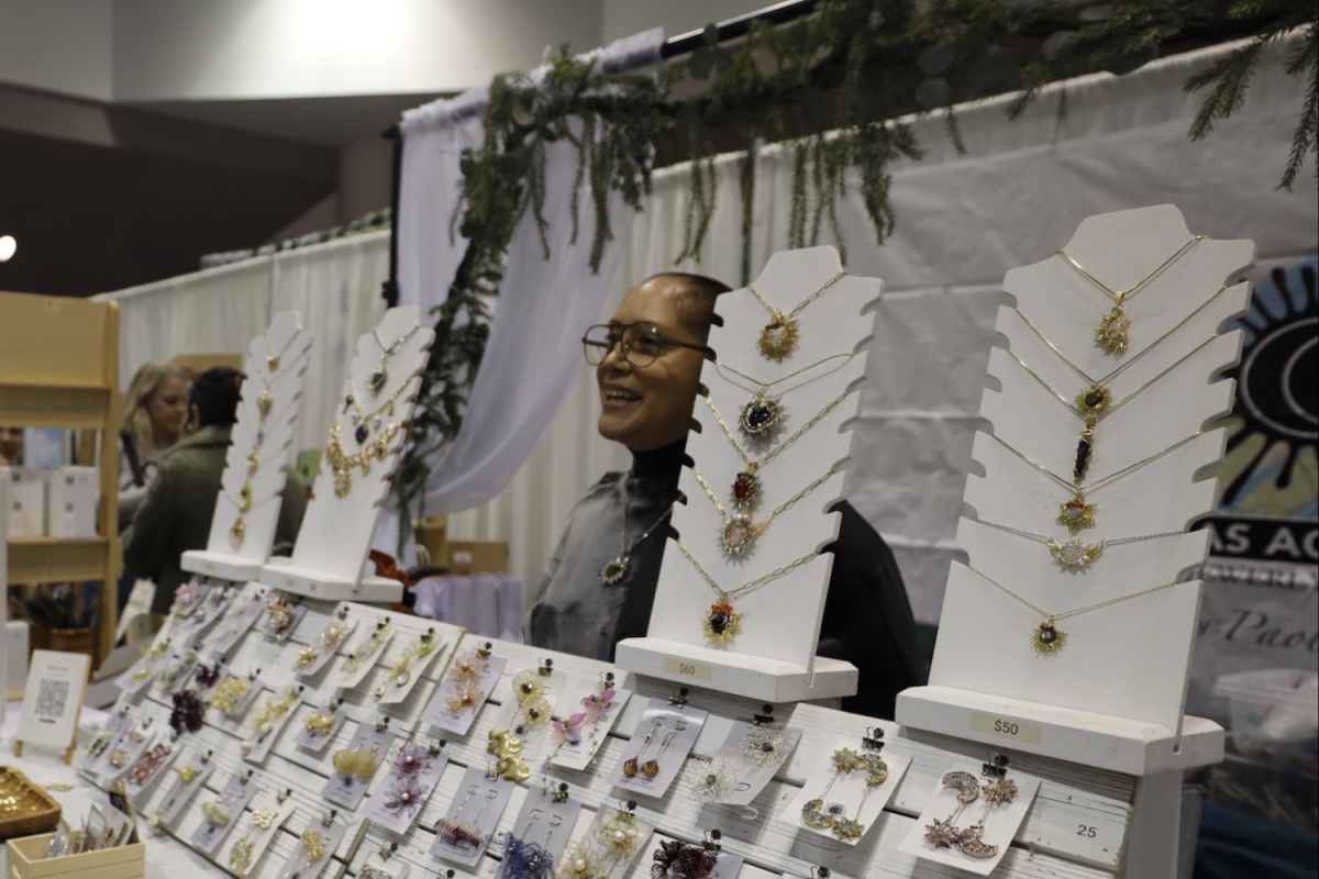 A vendor sells handmade wire-wrapped jewelry at the SJMADE Holiday Craft Fair. 