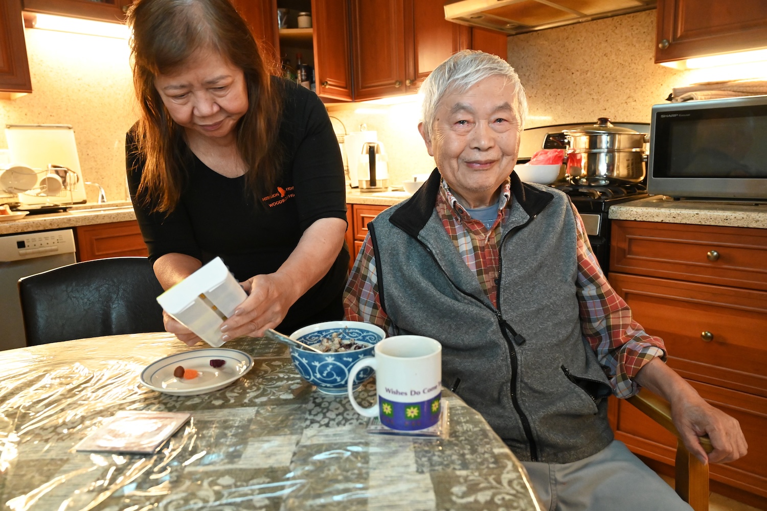 Corazon Caldejon, a paid caregiver, helps a patient with his morning medicine and breakfast. As a caregiver, Caldejon assists with medications, schedules, and accompanies patients to appointments, and helps with daily tasks such as bathing and laundry. “I’ve devoted my heart to caregiving,” Caldejon said. 