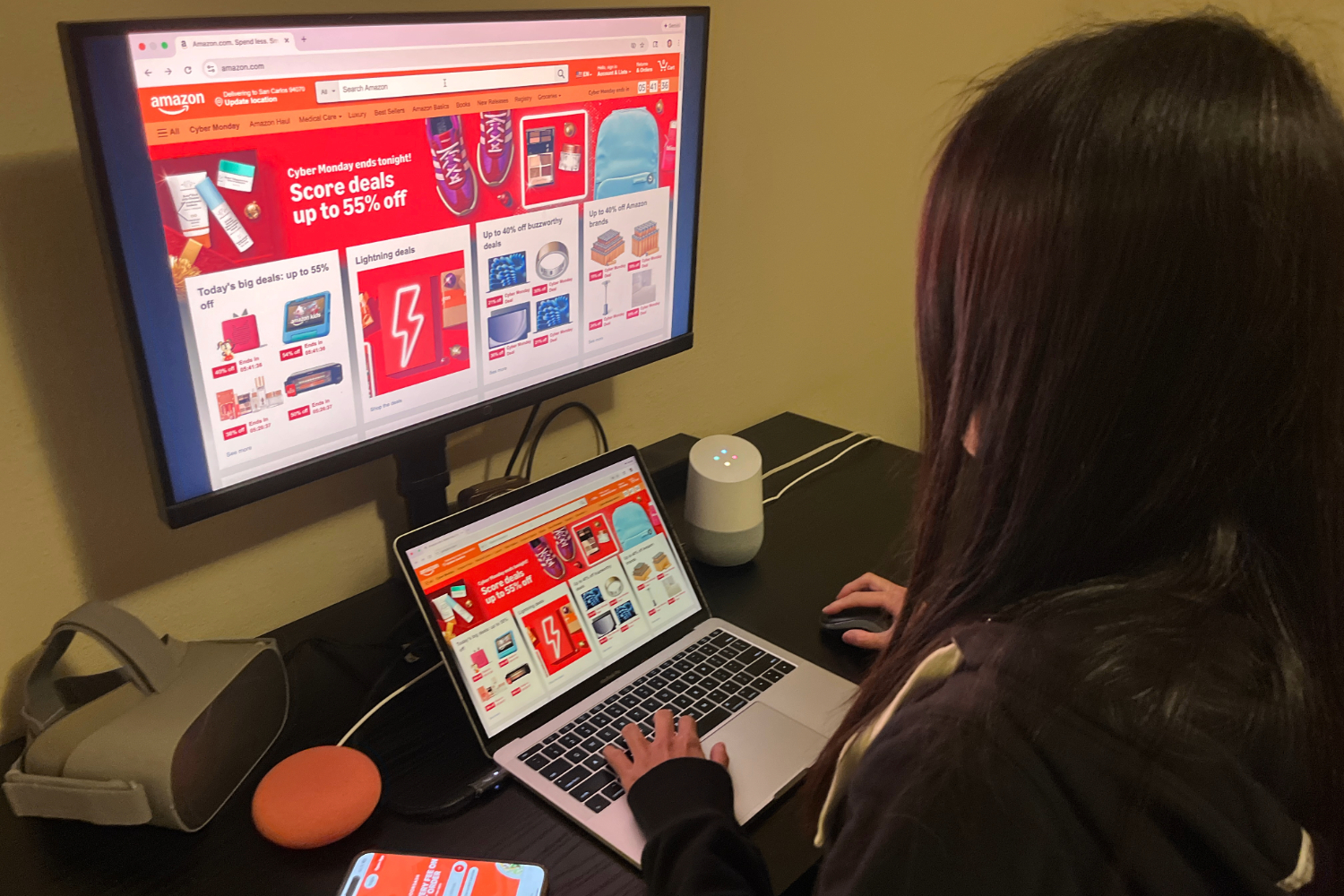 An online shopper browses for deals on Cyber Monday, surrounded by devices readily available for a purchase. Instead of interacting in crowded stores, many now shop alone at home, reducing chances for in-person social connection.