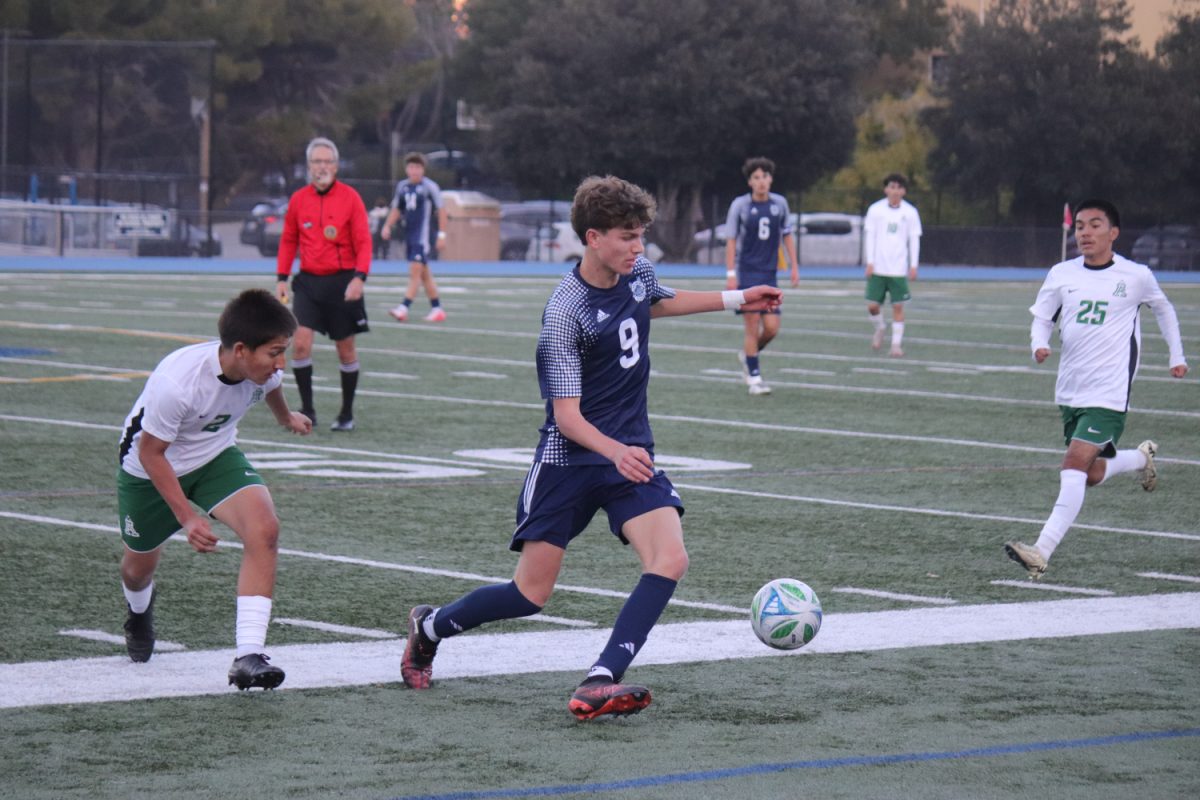 Ian Sijbrant dribbles the ball away from a defender. The Trojan defenders were very aggressive. Many free kicks were awarded to the Scots.