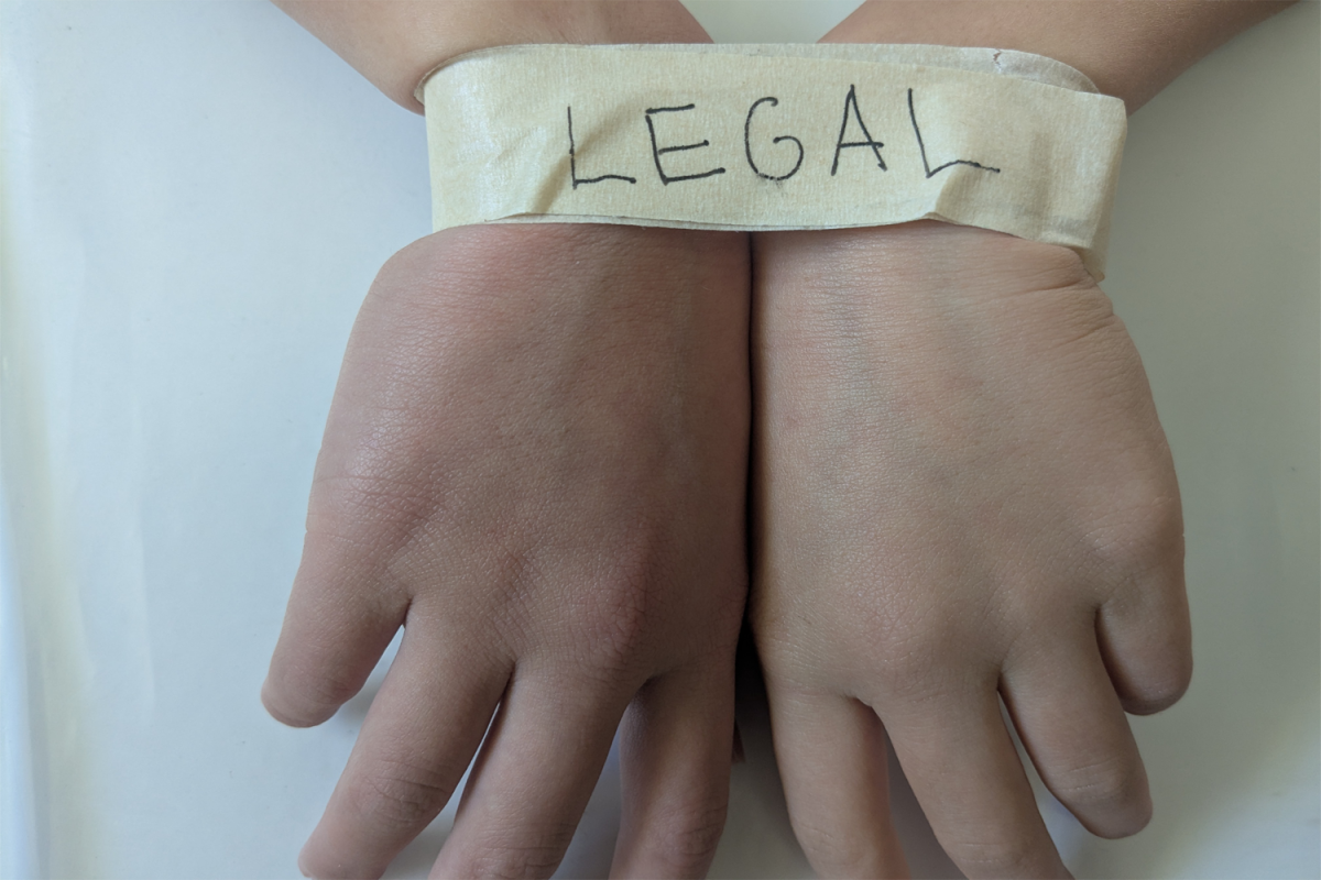 A pair of hands are tied together, with the writing signifying that the person is a legal immigrant. Combined with the stories of legal immigrants being detained, it is clear that no one is safe from detention, and even deportation.