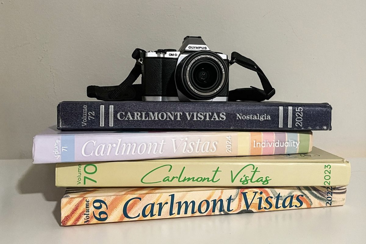 A camera rests on a stack of past yearbooks, representing the thousands of photos taken by staff each year. At the beginning of the annual process, the editorial staff decides on the yearbook theme. "Some things are consistent from year to year, but how those things are realized is up to the creative vision of our editorial staff," said Joseph Espinosa, the yearbook advisor. 