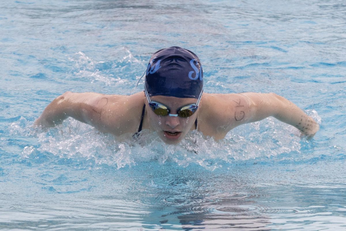 Junior Lauren Henne powers through the 100-yard butterfly. Her strong effort in the pool showed the team's collective energy and support. "Our team is really hyped, full of energy, and I feel that we're all really close together as one team," Choong said.