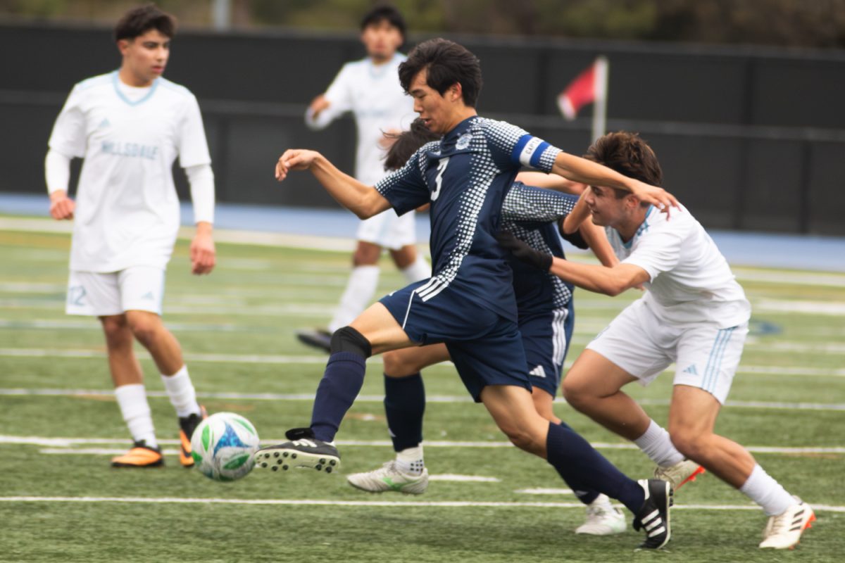 Senior Alex Kim controls the ball upfield away from the Scots' goal. Kim is one of the three team captains of the varsity team. Throughout the match, he put strong midfield pressure on Hillsdale's offense. 