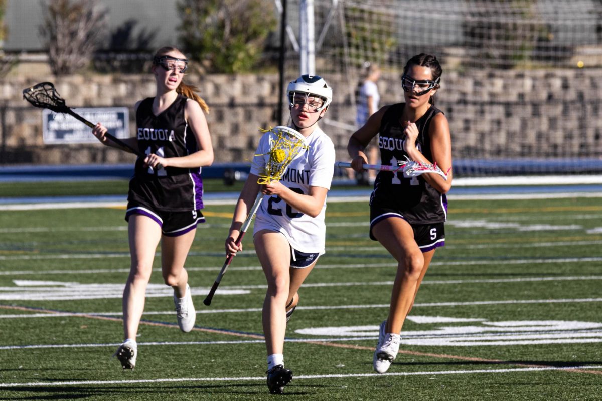 Wells advances the ball upfield with a Ravens defender trailing her. Wells had pushed forward after a defensive stop. She had later taken a shot, putting pressure on the Ravens’ defense.