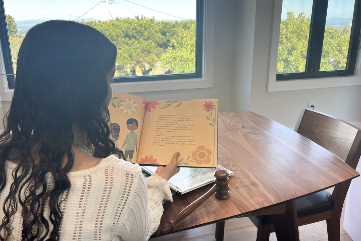 A student reads a children's book beside a wooden gavel, representing the new electives coming to Carlmont High School. Many students feel these additions provide a much-needed balance to the course catalog. "There's a bunch of classes with STEM, but there's not a lot have to do with the humanities or legal work," said Carlmont sophomore Alina Robinson.