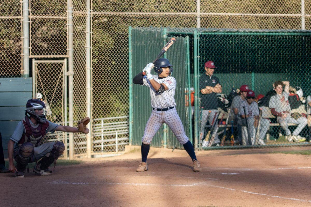 Sophomore Jakob Wolff prepares to hit the ball. The pitcher for Sacred Heart Prep threw the ball as his teammates watch from their dugout. After Wolff's swing, he quickly ran to first base. "We played well, good enough to win," said JV coach Michael Simon.