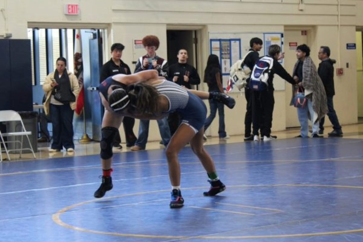 Carlmont junior Uiwailani Lobato drives her opponent to the mat during a wrestling match. Moments like this show the intensity and dedication behind girls sports, even when the stands aren’t full. Female athletes at Carlmont continue to compete with the same passion and drive as their male counterparts, pushing for equal recognition. 