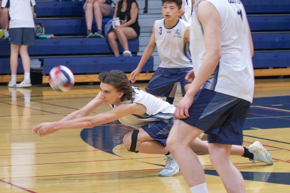 Freshman Eugene Zhukov dives forward to keep the ball alive during a fast-paced rally. The play showed the effort and urgency as the team fought to extend the point. "We played a lot better than our previous matches," Mayenkar said.