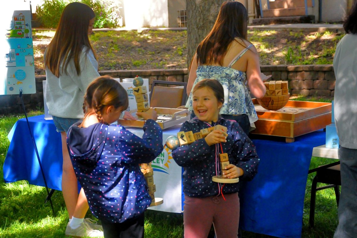 Two girls learn about the food chain as they play with a carnival game from 350 Silicon Valley's booth. These carnival games, developed by Andrew Breithaupt, allow kids and adults alike to learn about topics such as climate change, environmental conservation, and ecology while having fun. "After the 2016 election, Andrew got extremely depressed about the future, and he didn't know what to do. So, he devised these games. The idea is to bring these games to attract attention, get people engaged, and educate them," said Cheryl Weiden, a member of the Steering Committee for 350 Silicon Valley.
