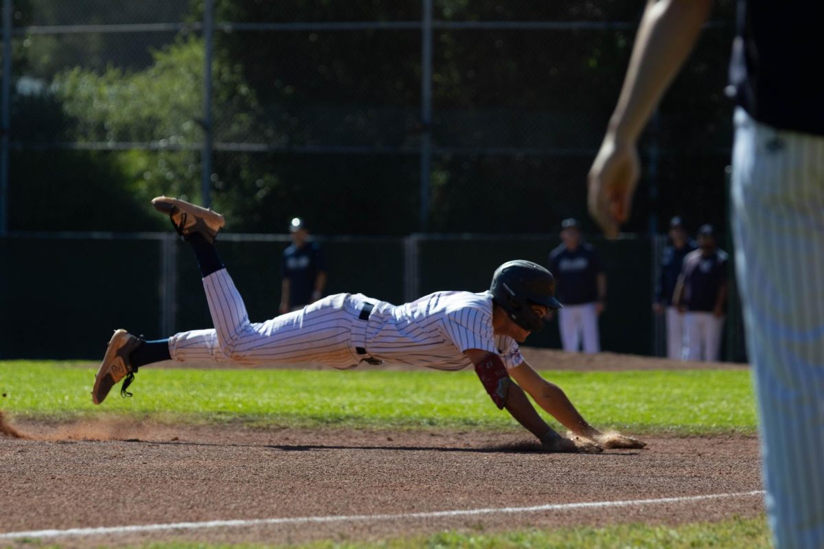Scots junior Nathan Werbinski slides safely into third base after a deep hit to right field. Werbinski contributed consistently at the plate throughout the game. He finished with three hits and a .750 batting average.