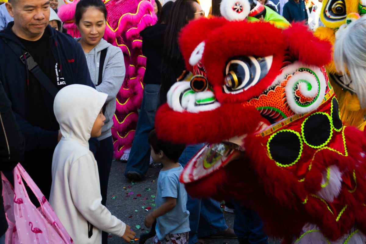 A kid walks up to the lion dancers during their performance while they interact with the crowd. One of the main reasons the dancers perform is to give back to the community, especially to the kids. “One of my favorite parts today was definitely seeing the kids, because they can give many different reactions,” Brandon Nguyen said.