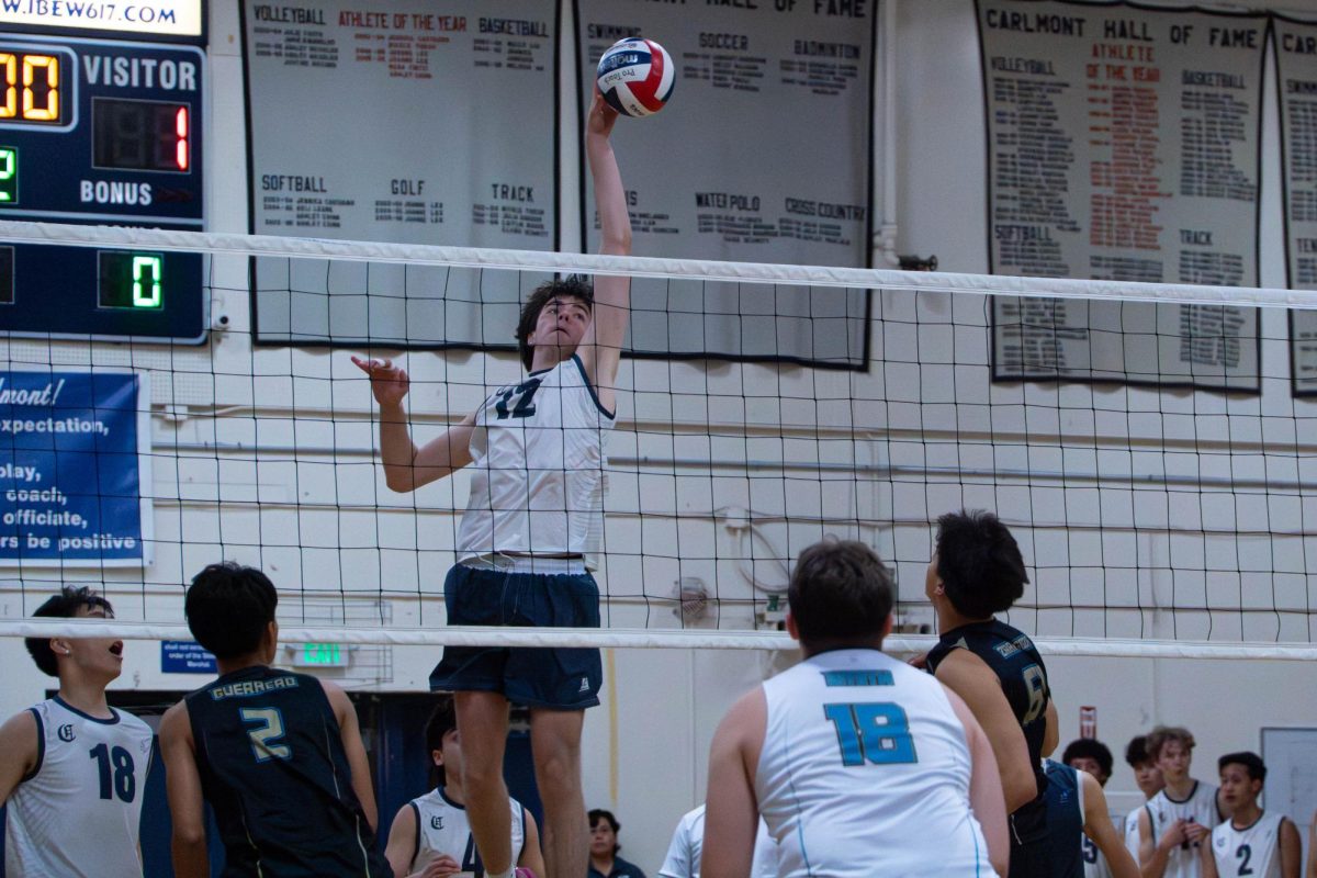 Daniel Larsen, a Scots sophomore, taps the ball over the net during a rally. The Scots had mixed in tips and off-speed plays to disrupt the Cougars’ defense. Larsen’s shot had scored a point during the close game.